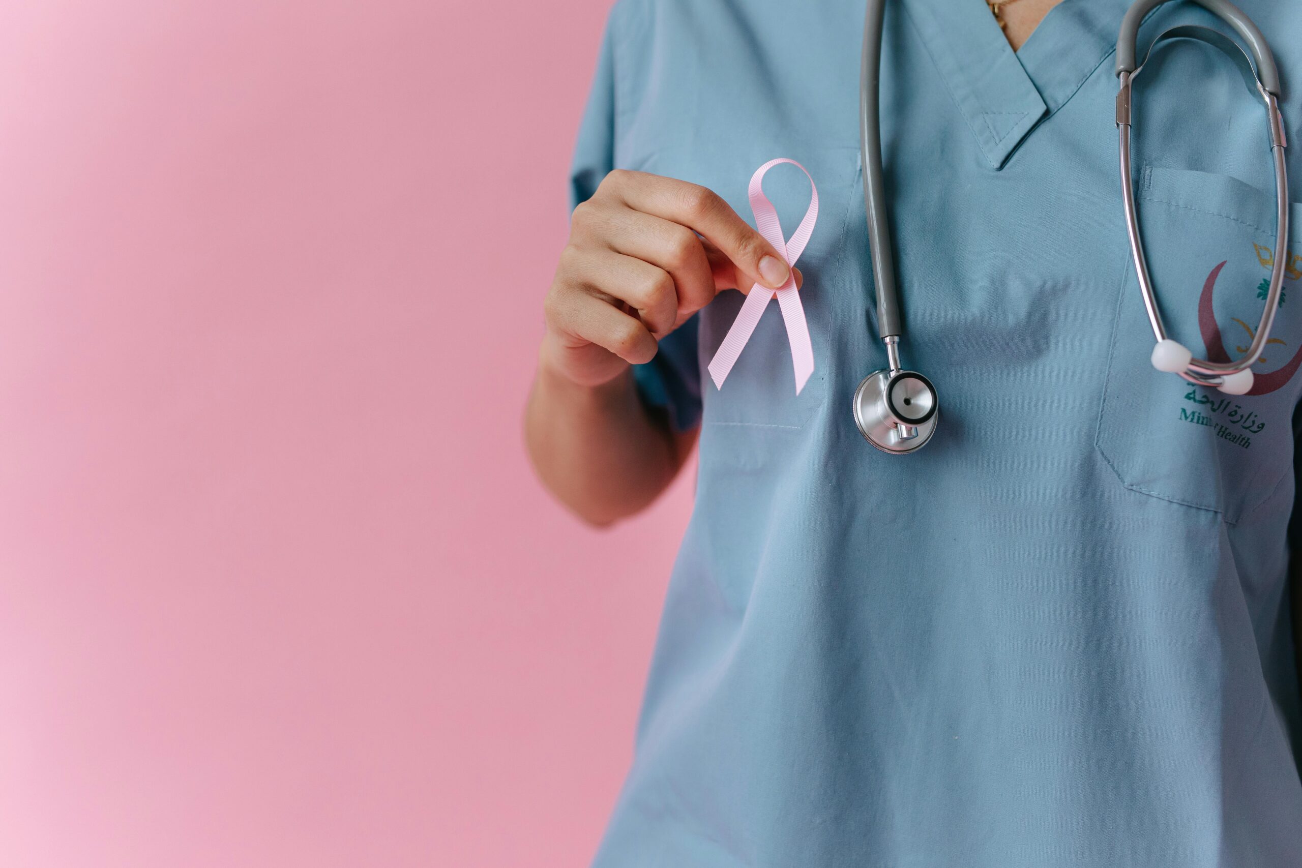 Medic care tine in manda o fundita roz care semnifica lupta impotriva cancerului la san